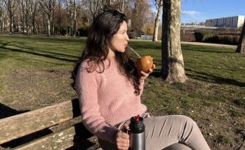 Femme buvant un maté sur un banc, moment de détente en extérieur